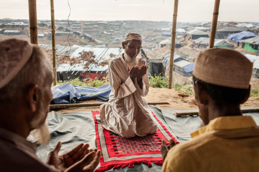 Imam Nurul, 53, during afternoon prayers at a makeshift mosque in Kutupalong refugee camp, Cox's Bazar District, Bangladesh. Patrick Brown © Panos/UNICEF 2018