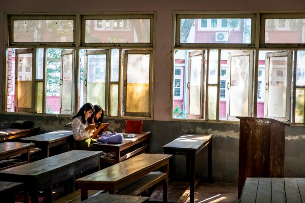 Two Yadanabon University students sitting in a classroom. The students’ protests argued that the university should invest more resources into classroom needs, such as chairs and study materials. ©Hkun Lat, January 2020